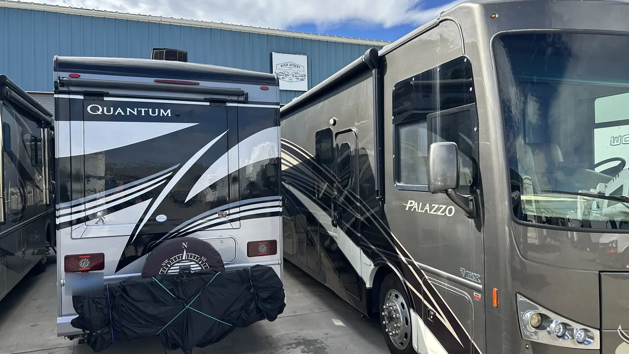 Two Class A motorhomes parked alongside the High Desert RV Services building